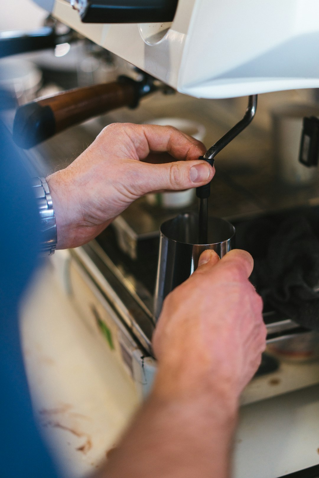 a-close-up-of-a-person-operating-a-coffee-maker-8kqh1v6ekdw
